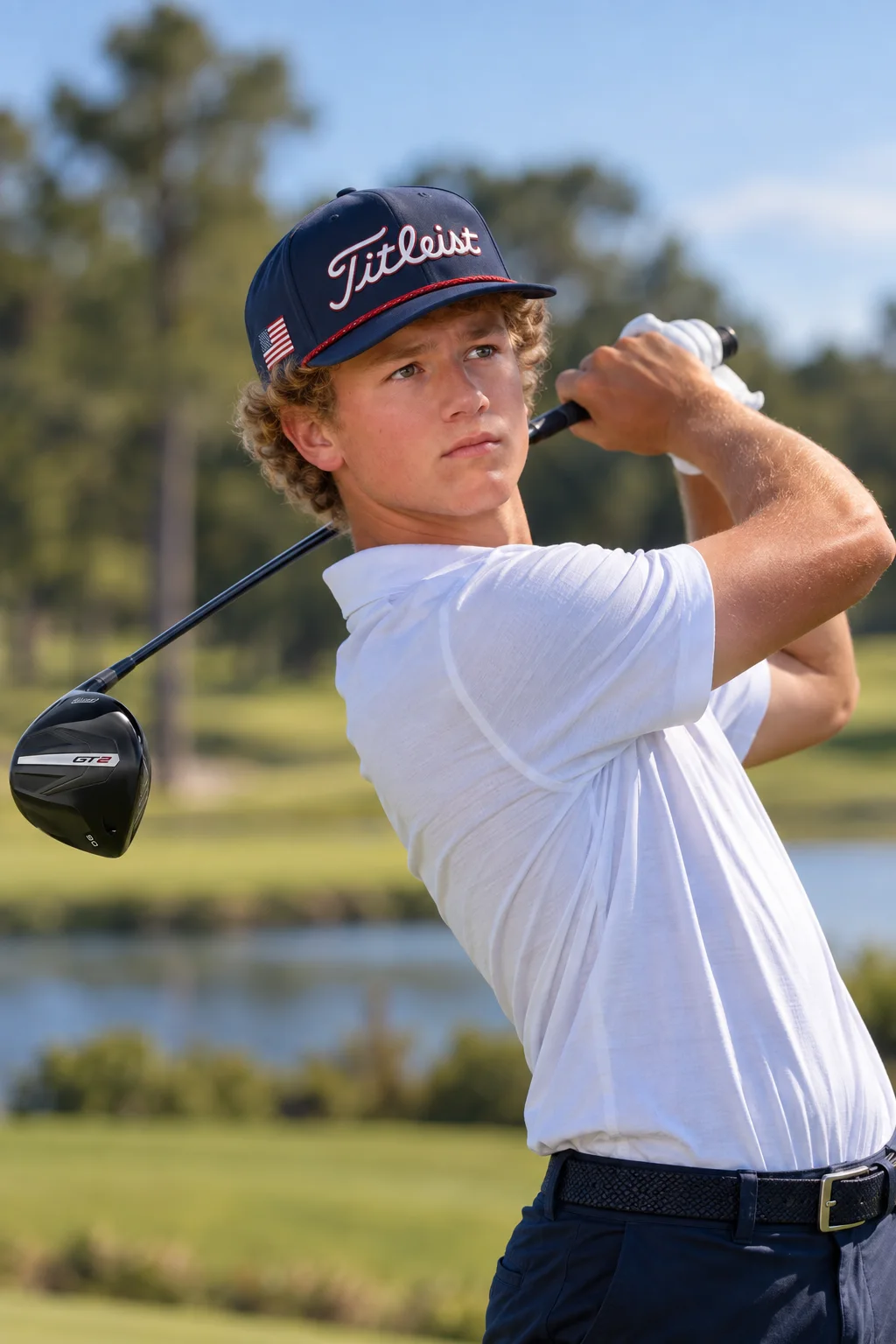 Peter Sirianni following through on a golf swing, wearing a Titleist cap and white polo.